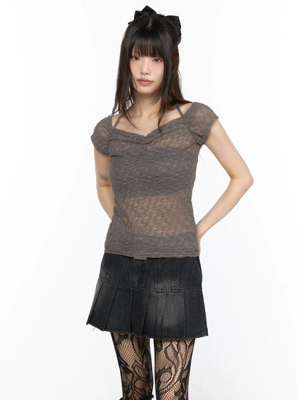 Sheer Lace Halter Off-Shoulder Tee CL522 Dark beige front view on model hands in pockets sheer lace texture V-neckline with halter strap styled with black pleated mini skirt