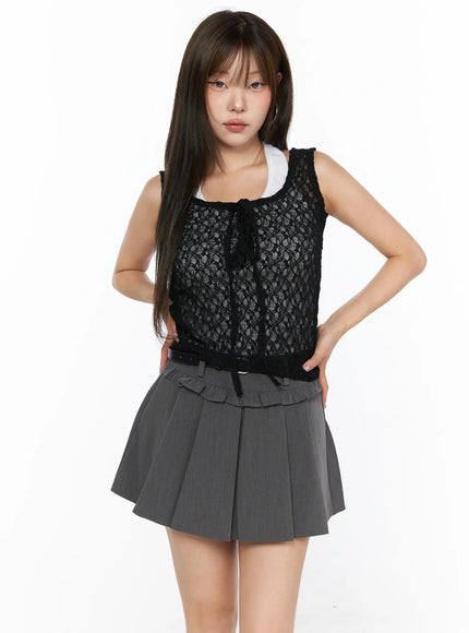 Sheer Lace Ribbon Tank Top CL514 Black front view on model hand on hip layered over white tank top with gray ruffle-waist pleated mini skirt showing full floral lace texture and ribbon closure