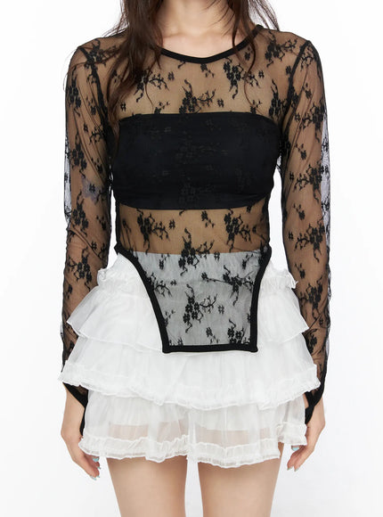 Sheer Lace Slit Long Sleeve Tee CL522 Black close-up front torso shot on model showing floral lace sheer fabric crewneck bandeau inner panel and slit hem detail with white ruffle skirt