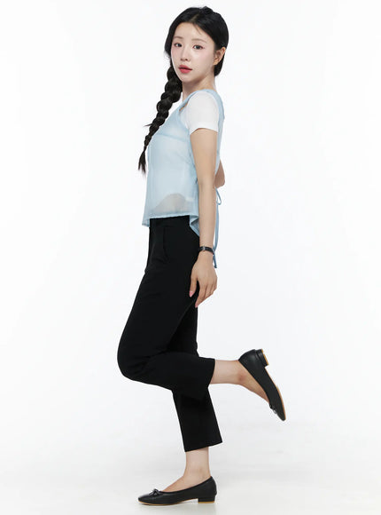 Sheer Layered Blouse IU525 Light blue side model shot, model lifting one leg, sheer vest with visible back tie detail, layered over white tee