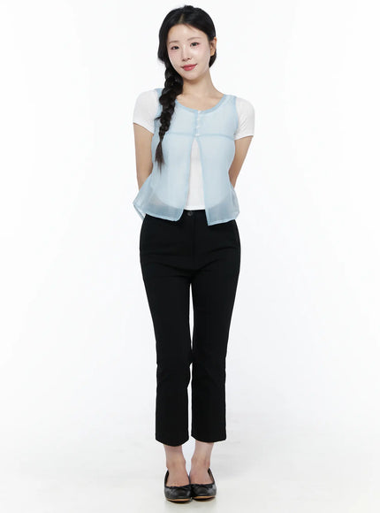 Sheer Layered Blouse IU525 Light blue front model shot, hands clasped, semi-sheer sleeveless vest with button detail over white short-sleeve tee