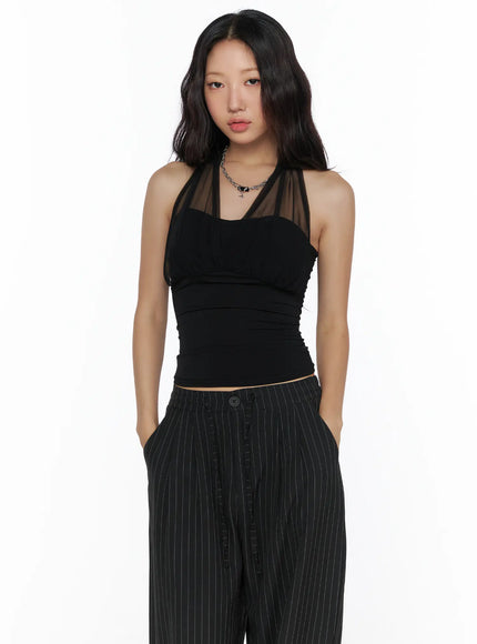 Sheer Layered Halter Top CL513 White full-body front model shot with black baker boy cap, navy pleated midi skirt, double leather belt and pinstripe wide-leg trousers