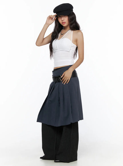 Sheer Layered Halter Top CL513 White side-angled model shot with baker boy cap, ruched waist detail visible, layered with navy skirt and pinstripe trousers