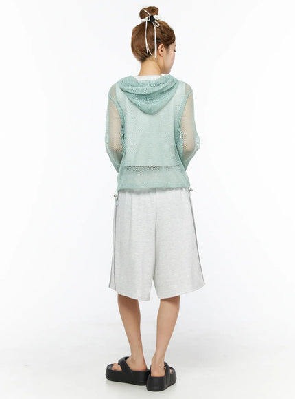Sheer Mesh Hoodie CL501 Mint back model shot sheer open-knit mint mesh hoodie showing hood and drawstring hem styled with grey bermuda shorts