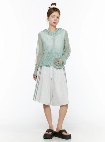 Sheer Mesh Hoodie CL501 Mint full-body front model shot zip-up sheer mint mesh hoodie with kangaroo pockets styled with grey striped bermuda shorts