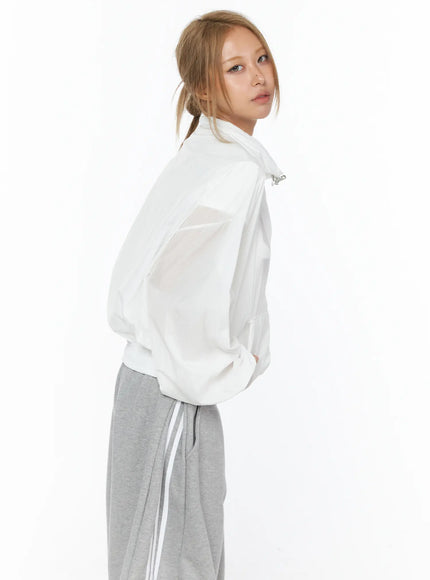 Sheer Nylon Windbreaker CU523 White back three-quarter shot on model glancing over shoulder showing rear seam detail semi-sheer fabric with gray pants