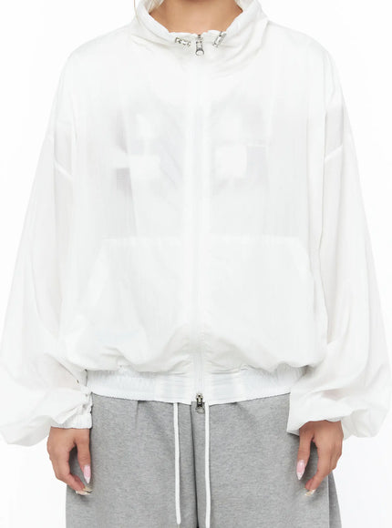 Sheer Nylon Windbreaker CU523 White close-up front detail shot on model showing silver zipper clasp collar sheer nylon texture and oversized patch pockets