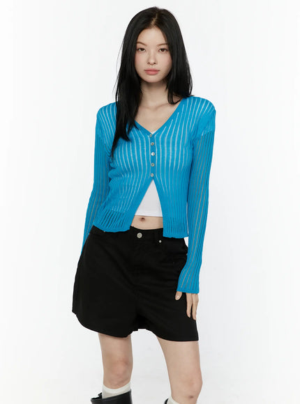 Sheer Ribbed Cardigan IL506 Blue half-length front shot on model standing forward showing sheer ribbed stripe knit V-neck cardigan layered over white top with black mini skirt