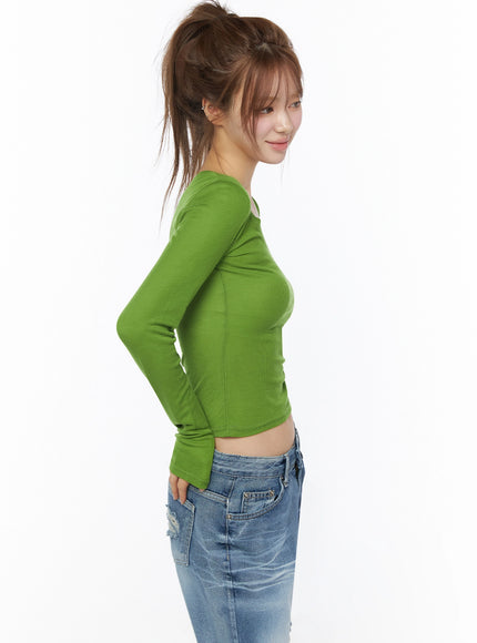 Sheer Slim Fit Long Sleeve Top IU525 Green side view on model with high ponytail hand on hip showing side seam ribbed texture slim crop silhouette paired with jeans