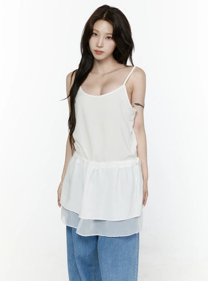 Sheer Strap Layered Dress IL521 White half-body front view on model with direct gaze, showing spaghetti straps, scoop neck, peplum waist, sheer hem, styled with blue jeans