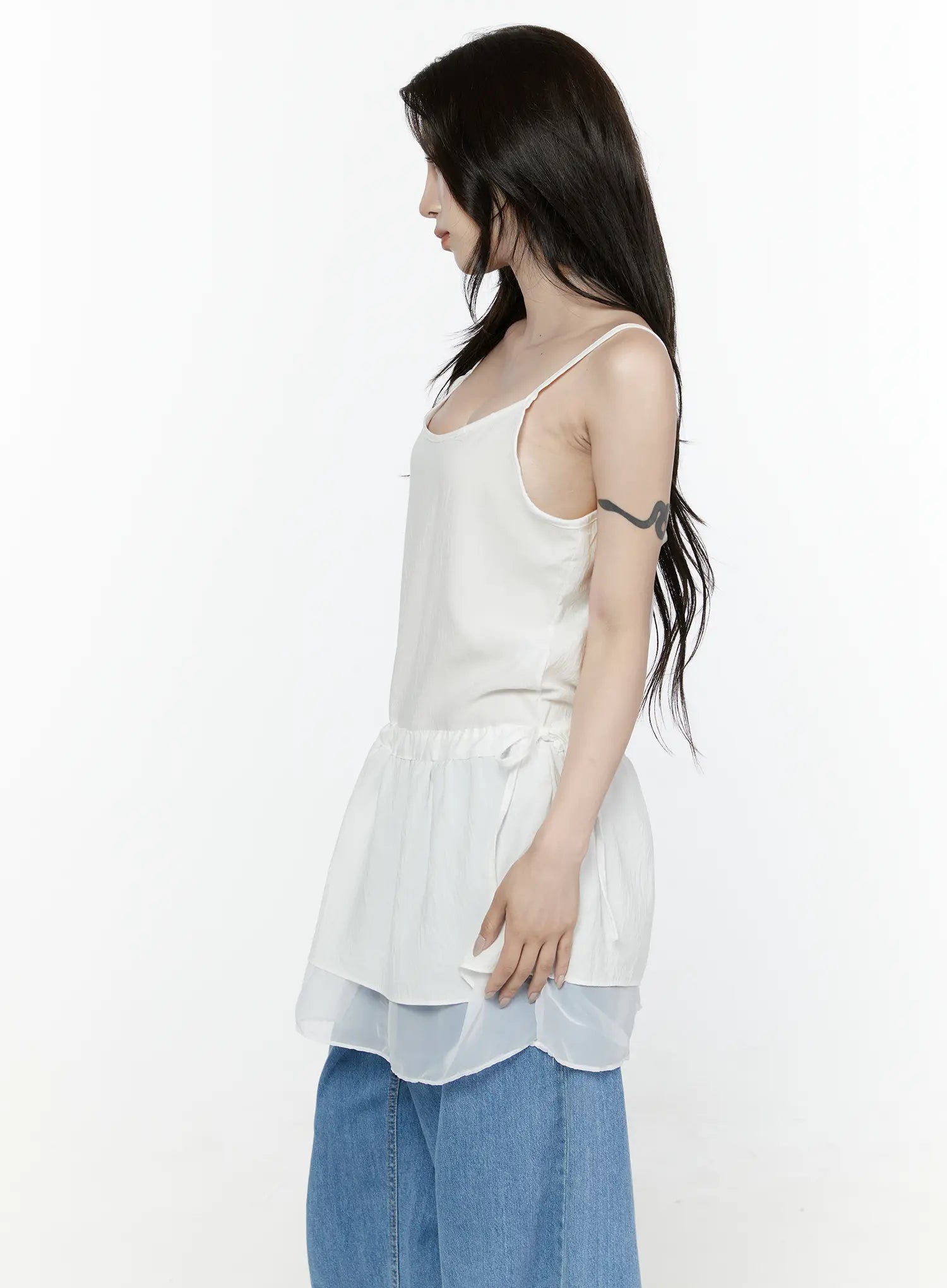 Sheer Strap Layered Dress IL521 White side view on model showing silhouette of peplum frill, drawstring waist tie, and translucent double-layer hem with wide-leg jeans