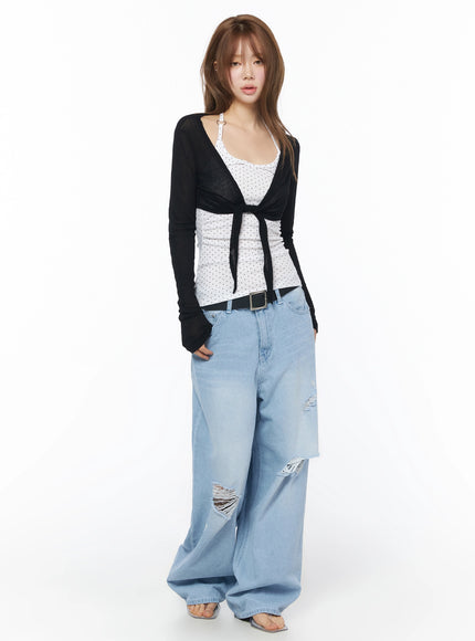 Sheer Tie-Front Wrap Crop Cardigan IL502 Black full-body front model shot standing sheer lightweight knit tie-front crop styled with polka dot inner and baggy denim