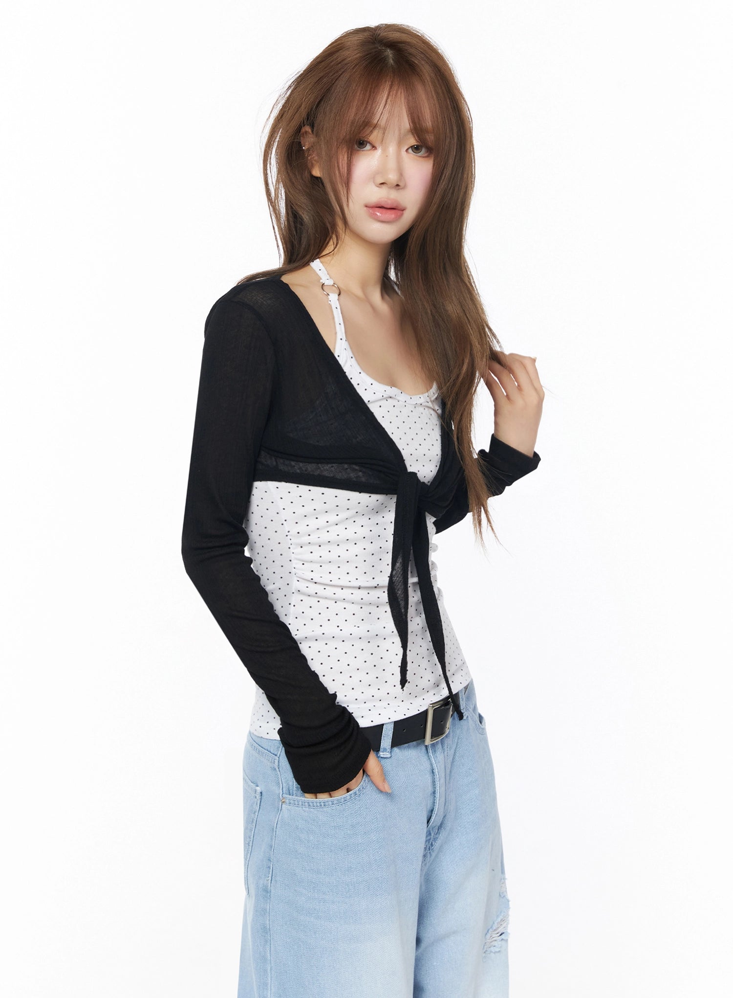 Sheer Tie-Front Wrap Crop Cardigan IL502 Black three-quarter angle model shot model touching hair showing sheer tie-front crop cardigan layered over polka dot cami