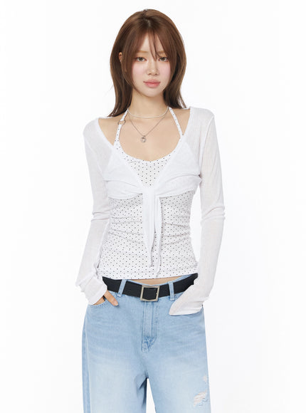 Sheer Tie-Front Wrap Crop Cardigan IL502 White front model shot semi-sheer long sleeve tie closure layered over white polka dot tank with light wash jeans