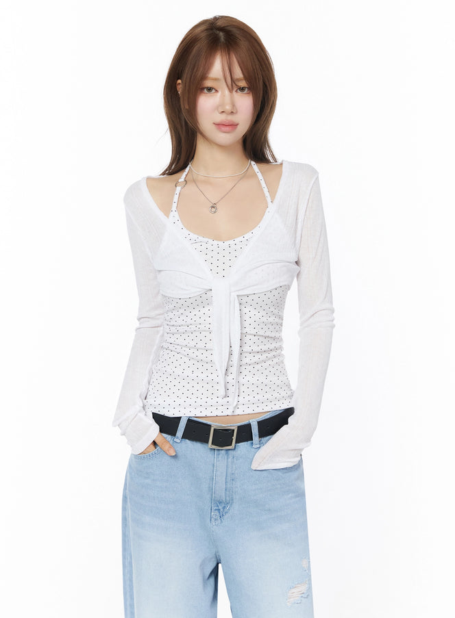 Sheer Tie-Front Wrap Crop Cardigan IL502 White front model shot semi-sheer long sleeve tie closure layered over white polka dot tank with light wash jeans