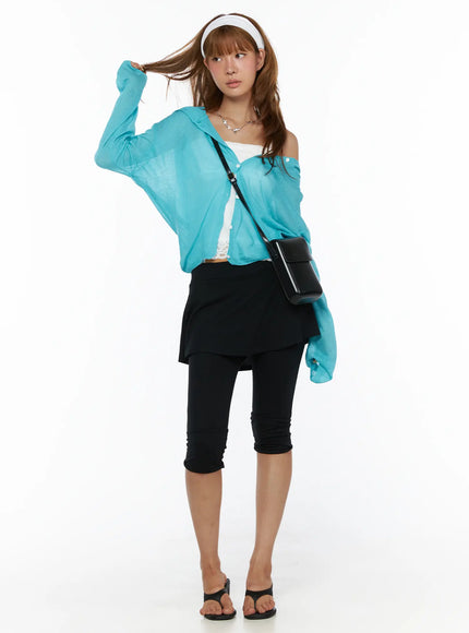Sheered Hooded Cardigan CL503 Blue full-length front shot on model holding hair, hood down, open cardigan styled with white bandeau and black crossbody bag, cropped leggings