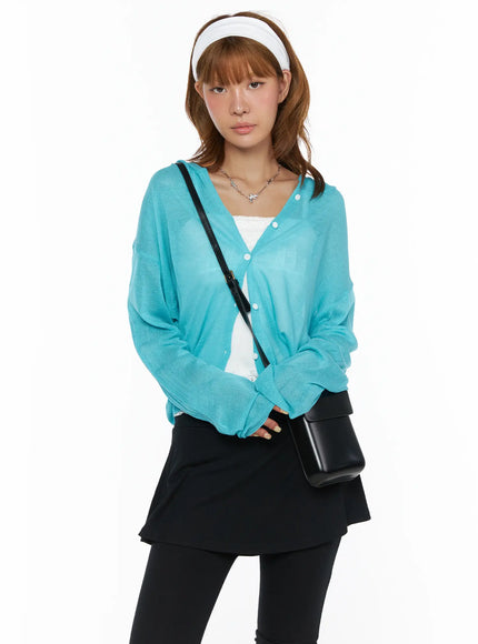 Sheered Hooded Cardigan CL503 Blue front shot on model with white headband, hood down, sheer knit buttoned cardigan styled with black crossbody bag and black skirt