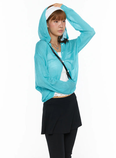 LEWKIN Sheered Hooded Cardigan CL503 Blue S/M side shot on model wearing hood up, hand raised to head, sheer knit texture visible, styled with white lace top and black skirt