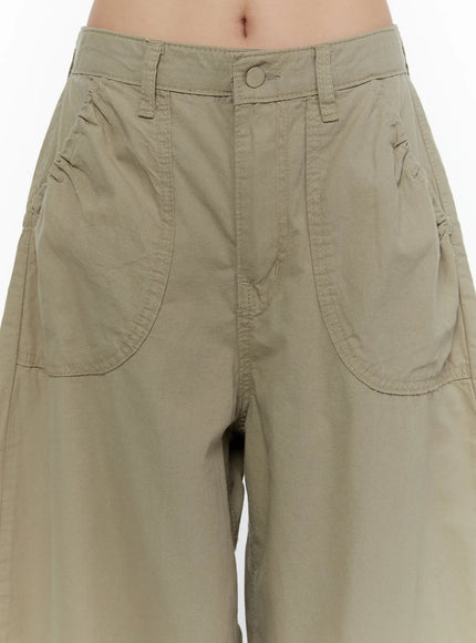 Shirred Balloon Cotton Trousers CL507 Dark green close-up detail of front waistband, button closure, and large patch pockets with visible stitching