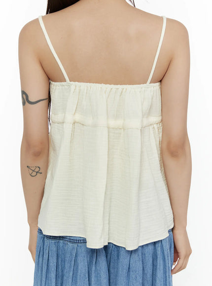 Shirred Cami Top CL508 Light beige back close-up shot on model showing thin spaghetti straps, elasticated back neckline, tiered seam and flared crinkle texture hem