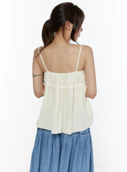 Shirred Cami Top CL508 Light beige back shot on model with ponytail, thin spaghetti straps, gathered back yoke seam detail and relaxed flowy silhouette over denim skirt
