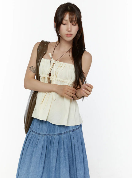 LEWKIN Shirred Cami Top CL508 Light beige S/M front shot on model with brown shoulder bag, drawstring tie detail, flowy crinkle fabric, styled with blue denim maxi skirt