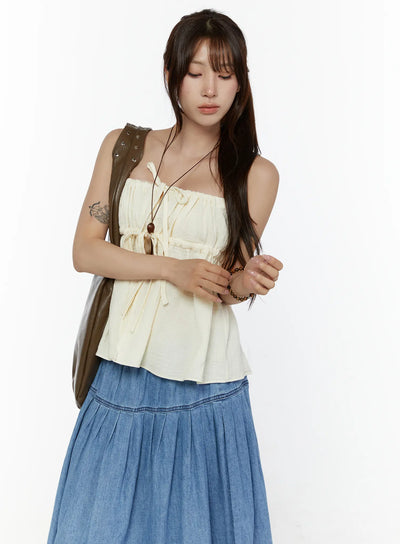 LEWKIN Shirred Cami Top CL508 Light beige S/M front shot on model with brown shoulder bag, drawstring tie detail, flowy crinkle fabric, styled with blue denim maxi skirt