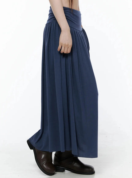 Shirred Flare Maxi Skirt IL502 Dark blue side waist-down shot on model, highlighting wide ruched waistband side detail and soft pleated drape, brown boots