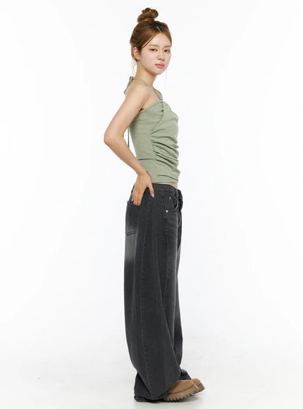 Shirred Halter Top CL501 Dark green side view on model showing ruched silhouette and halter strap, paired with charcoal wide-leg denim and brown boots