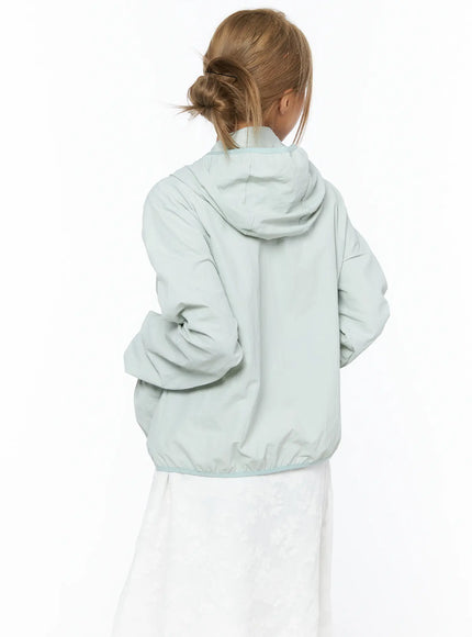 Shirred Hooded Windbreaker CU523 Mint back close-up model showing hood seam detail elastic hem and lightweight nylon fabric over white midi skirt