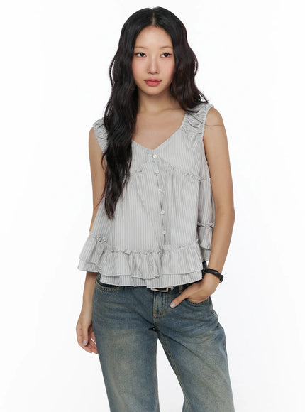 Shirred Ribbon Sleeveless Blouse CL510 Grey front shot on model in grey stripe colorway with ruffle shoulders, button front and tiered hem paired with jeans