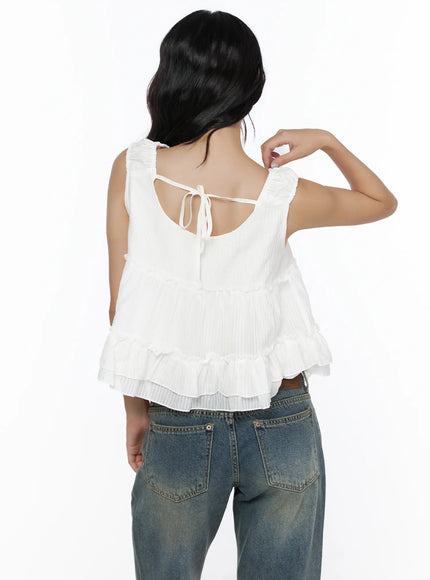 Shirred Ribbon Sleeveless Blouse CL510 White back shot on model with arm raised showing ribbon tie back closure, tiered ruffle hem and smocked shoulder detail