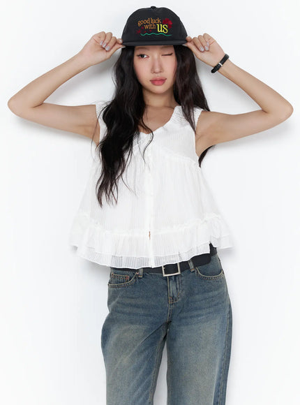 LEWKIN Shirred Ribbon Sleeveless Blouse CL510 White S/M front view on model adjusting black cap paired with wide-leg jeans, ruffle hem detail
