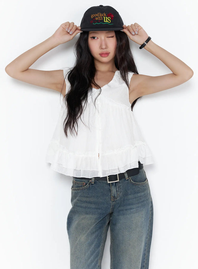 LEWKIN Shirred Ribbon Sleeveless Blouse CL510 White S/M front view on model adjusting black cap paired with wide-leg jeans, ruffle hem detail