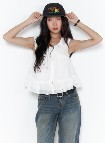 LEWKIN Shirred Ribbon Sleeveless Blouse CL510 White S/M front view on model adjusting black cap paired with wide-leg jeans, ruffle hem detail