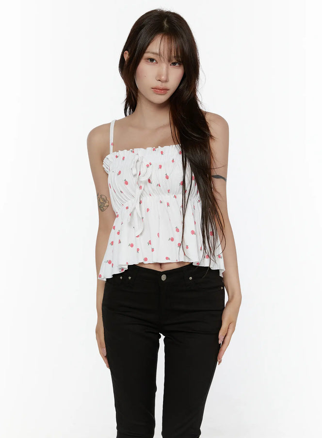 LEWKIN Shirred Ribbon Sleeveless Top CL507 White S/M front view on model wearing black skinny jeans, rose print smocked bodice with center ribbon tie and ruffle hem