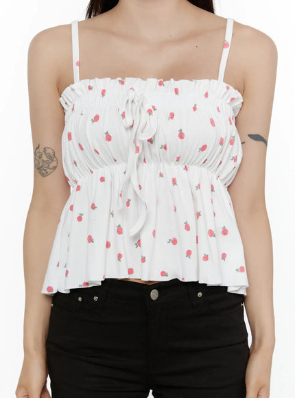 Shirred Ribbon Sleeveless Top CL507 White close-up front torso shot on model highlighting smocked bust, center ribbon bow tie and scattered pink rose print texture