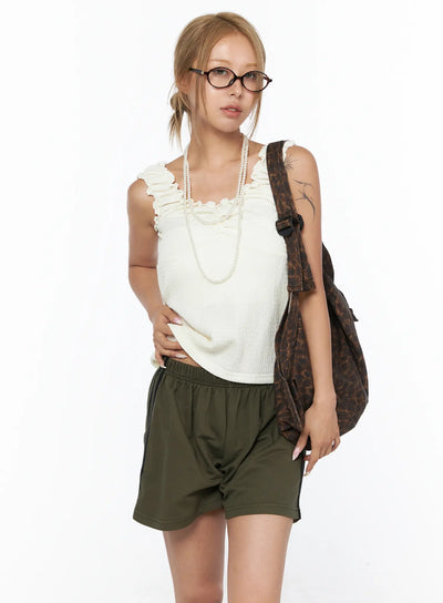 LEWKIN Shirred Ruffle Tank Top CU524 Light beige front view on model wearing glasses and pearl necklace with olive shorts and leopard backpack