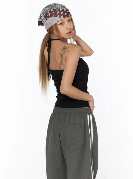 Shirred Strap Tube Top CU523 black back model shot showing open back halter tie neck detail paired with gray track pants