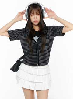 LEWKIN Short Sleeve Hooded Jacket IL523 Black front view on model wearing hood up with headphones, striped knit zip-up cropped fit, styled with white ruffle skirt and crossbody bag