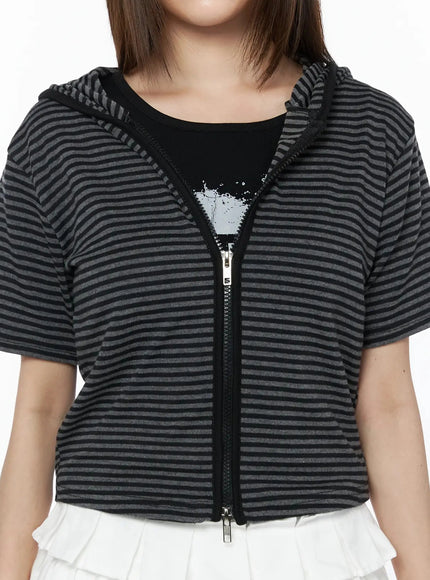 Short Sleeve Hooded Jacket IL523 Black close-up detail shot showing center-front zipper, hood construction, and black and gray horizontal stripe knit fabric texture on model