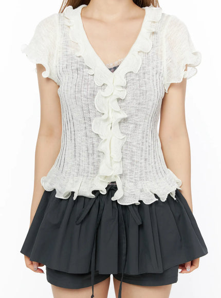 Short Sleeve Ruffle Cardigan CL501 White close-up front model shot torso detail, V-neck ruffle cascade and scallop hem on sheer ribbed lightweight knit