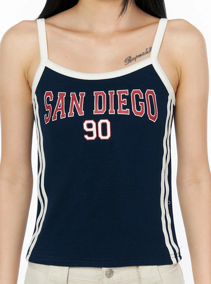 Side Stripe Contrast Trim Cami Top IL516 Dark blue close-up detail shot on model highlighting SAN DIEGO 90 red varsity graphic print cream contrast neckline and side stripes