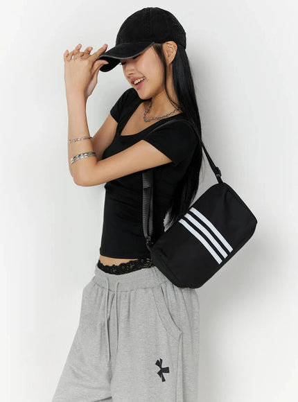 LEWKIN Silky Shirred Short Sleeve Tee IL509 Black S/M side shot model wearing fitted tee with ruched waist detail styled with gray wide-leg sweatpants and crossbody bag
