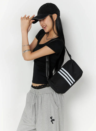 LEWKIN Silky Shirred Short Sleeve Tee IL509 Black S/M side shot model wearing fitted tee with ruched waist detail styled with gray wide-leg sweatpants and crossbody bag
