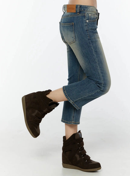 Simi Vintage Washed Capri Jeans IU524 Dark blue side action shot on model with one leg raised, showing back pocket, leather label, and cropped flare hem detail
