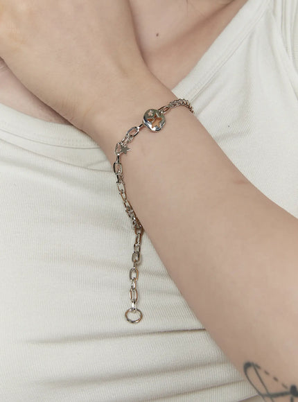 Skye Star Cut Bracelet IL522 silver worn on model wrist showing coin star pendant mixed chain and dangling extension against white ribbed top