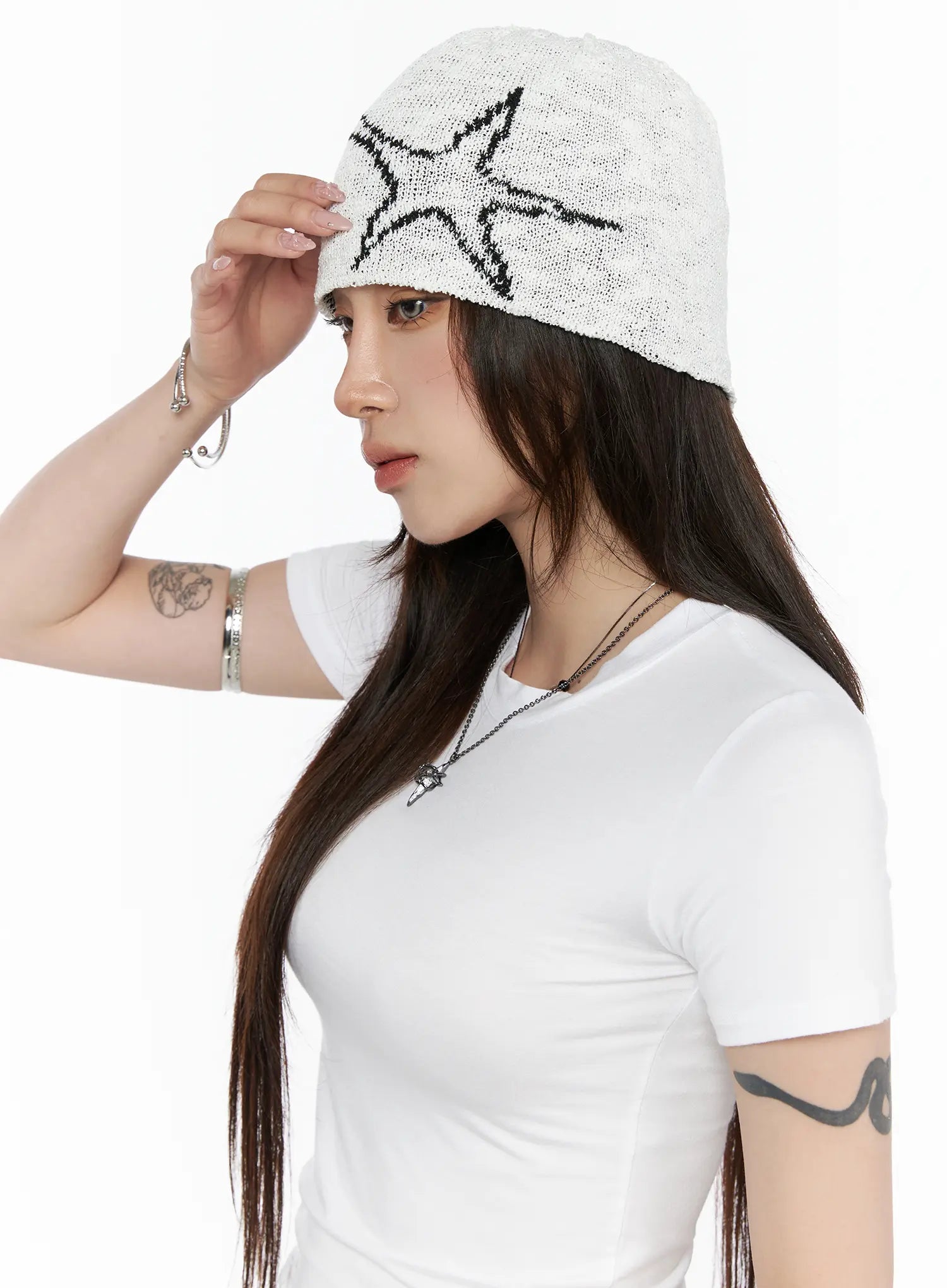 Slab Star Beanie IL503 White side view on model adjusting brim with hand, open-knit fabric with black star graphic, styled with white tee