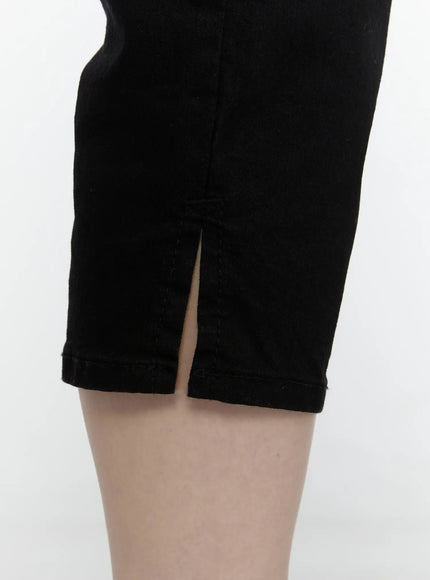 Slim Capri Pants IL521 Black close-up detail of hem leg opening showing front slit vent and denim texture on model