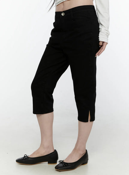 Slim Capri Pants IL521 Black side view on model from waist down showing slim fit silhouette, button waistband and side hem slit detail
